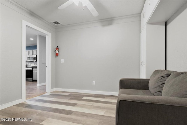 living area featuring crown molding, light hardwood / wood-style flooring, and ceiling fan