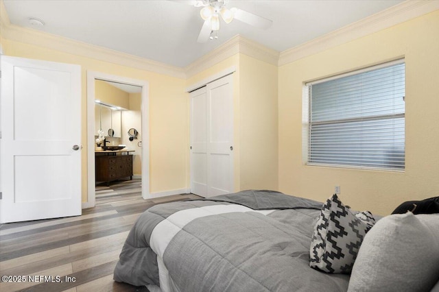 bedroom with a closet, ornamental molding, connected bathroom, and light hardwood / wood-style flooring