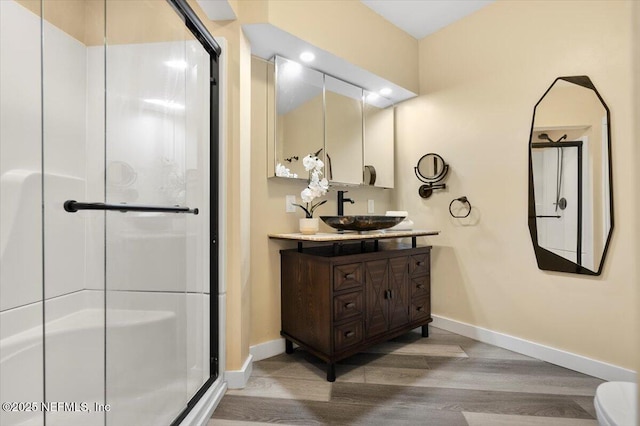 bathroom featuring walk in shower, vanity, and hardwood / wood-style floors