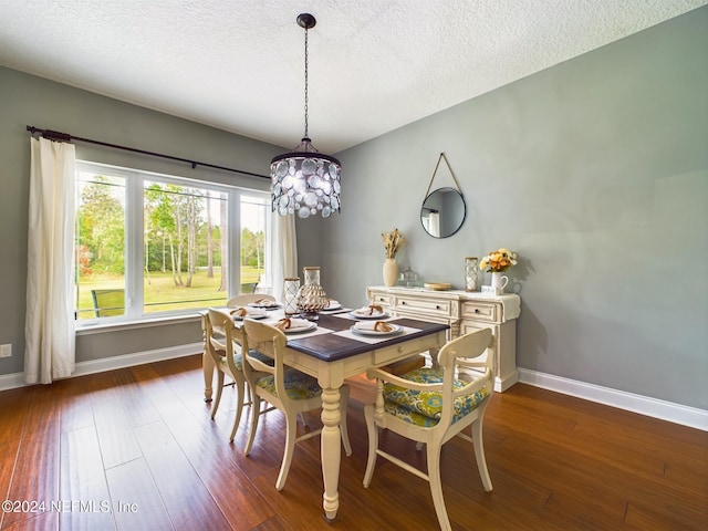 dining room with dark hardwood / wood-style floors and a textured ceiling