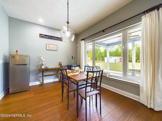 dining room with hardwood / wood-style floors and a textured ceiling