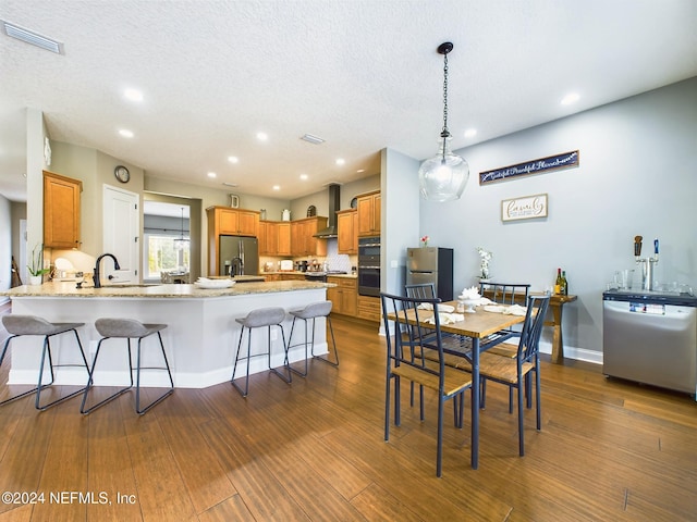 dining space with a textured ceiling, dark wood-type flooring, and sink