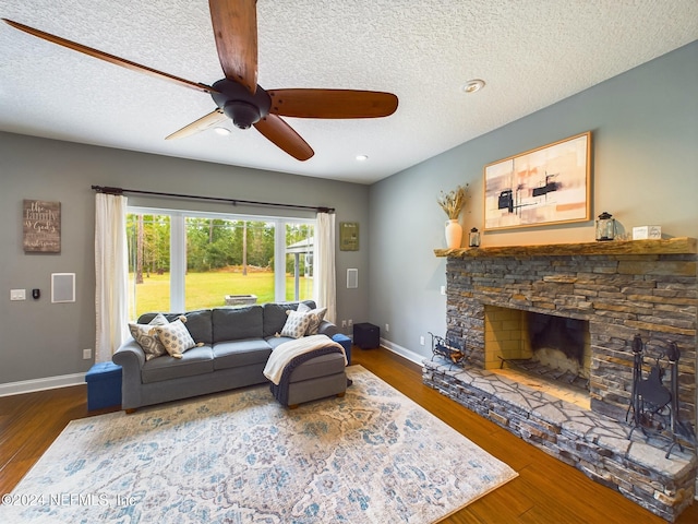 living room with a fireplace, dark hardwood / wood-style floors, and a textured ceiling