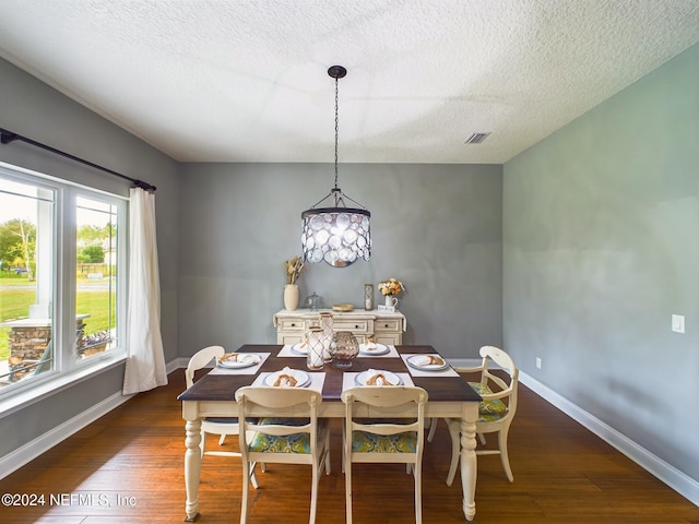 dining room featuring a textured ceiling and dark hardwood / wood-style floors