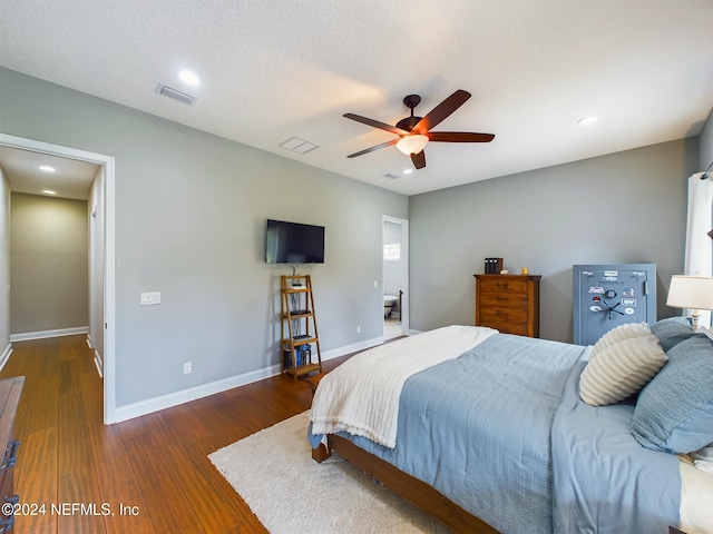 bedroom with a textured ceiling, dark hardwood / wood-style floors, and ceiling fan