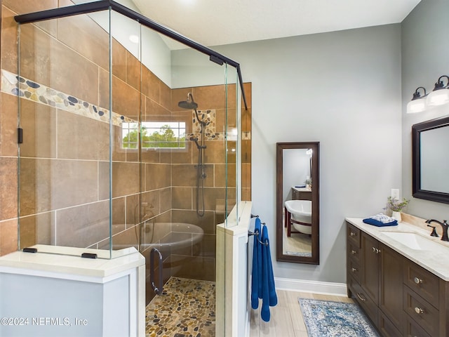 bathroom featuring a shower with door and vanity