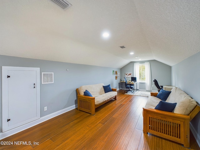 interior space with a textured ceiling, lofted ceiling, and hardwood / wood-style flooring