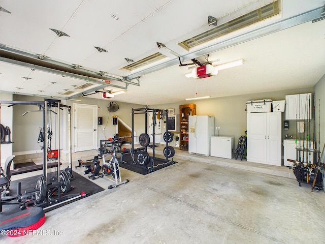 garage with a garage door opener and white refrigerator with ice dispenser