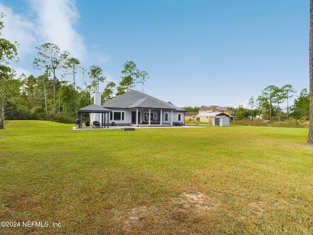 back of property featuring a patio area, a storage shed, and a yard