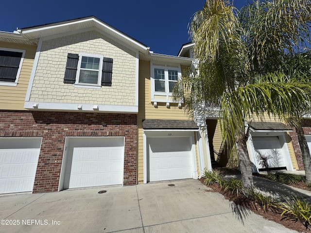 view of front of property with driveway, brick siding, and an attached garage