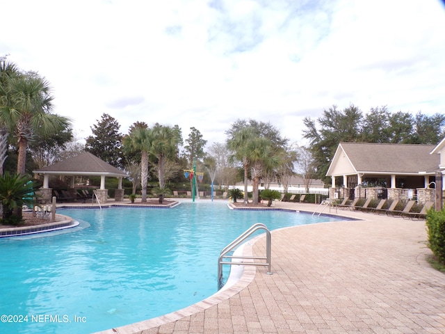 view of swimming pool with a gazebo, pool water feature, and a patio area