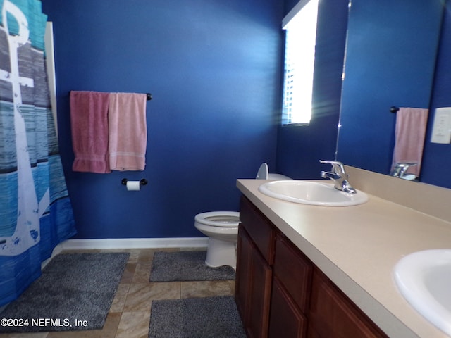 bathroom with tile patterned flooring, vanity, and toilet