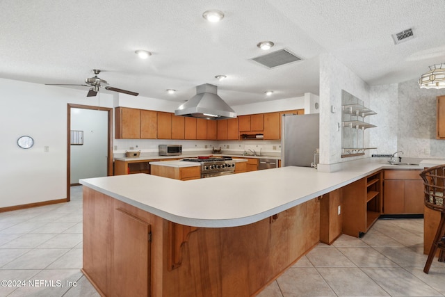 kitchen with island exhaust hood, ceiling fan, stainless steel appliances, and a textured ceiling