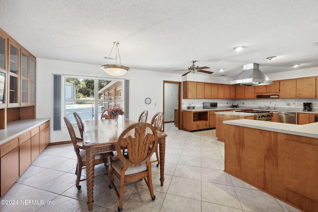 dining area with ceiling fan, light tile patterned flooring, and a textured ceiling