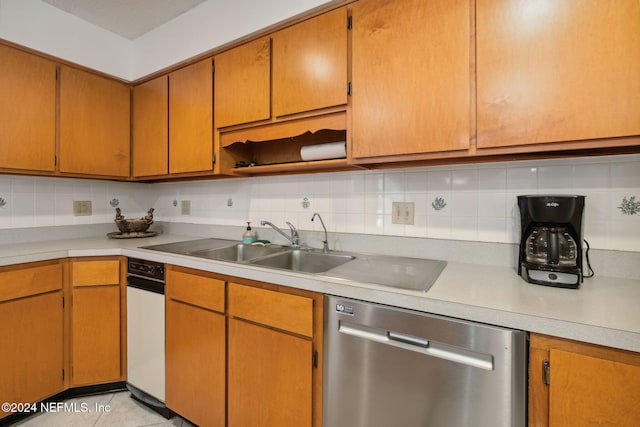 kitchen featuring dishwasher, light tile patterned floors, backsplash, and sink