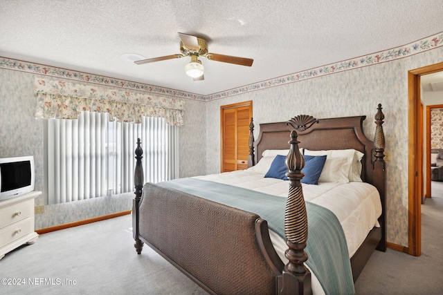 bedroom featuring ceiling fan, light colored carpet, and a textured ceiling