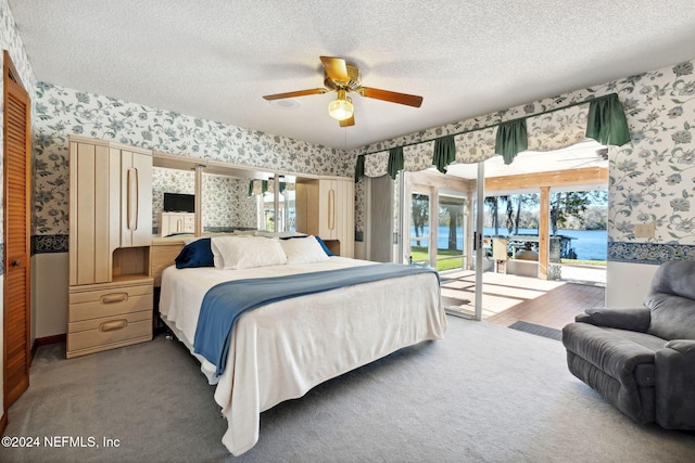 carpeted bedroom featuring access to exterior, a textured ceiling, a closet, and ceiling fan