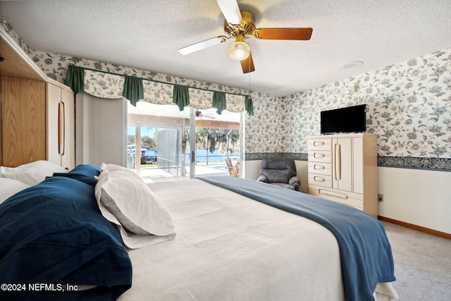 carpeted bedroom featuring ceiling fan, access to exterior, and a textured ceiling