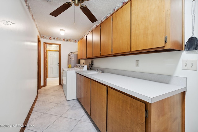 laundry area with ceiling fan, cabinets, electric water heater, a textured ceiling, and light tile patterned flooring