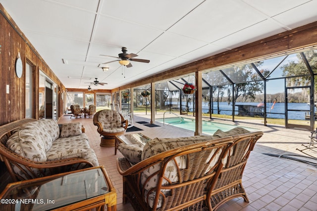 sunroom / solarium featuring a water view and ceiling fan