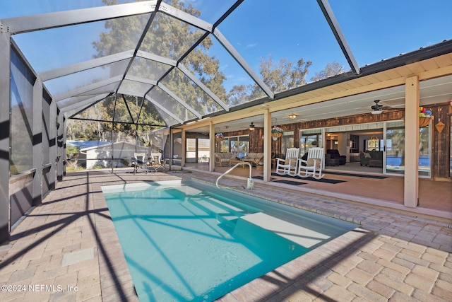 view of swimming pool with a lanai, ceiling fan, and a patio