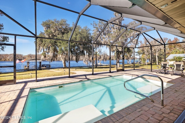 view of swimming pool with a patio, a water view, and glass enclosure