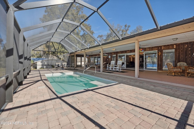 view of pool featuring a lanai, a patio area, and ceiling fan