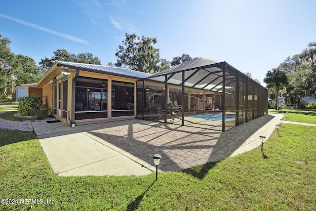 back of house with a patio area, a lanai, and a lawn