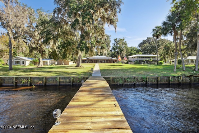 dock area featuring a lawn and a water view