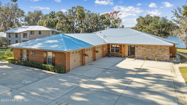 single story home with a water view and a garage