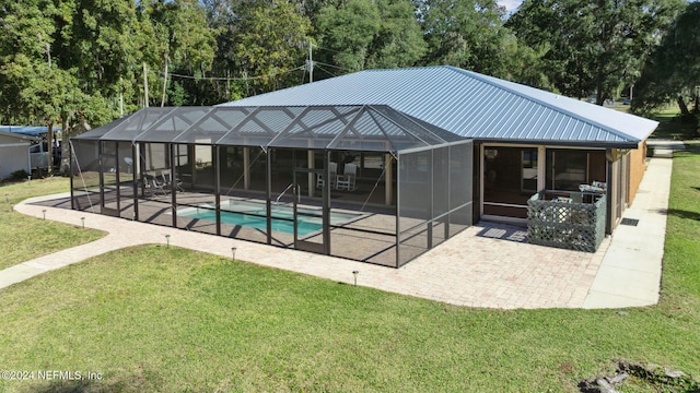 back of property with a lawn, a lanai, and a patio