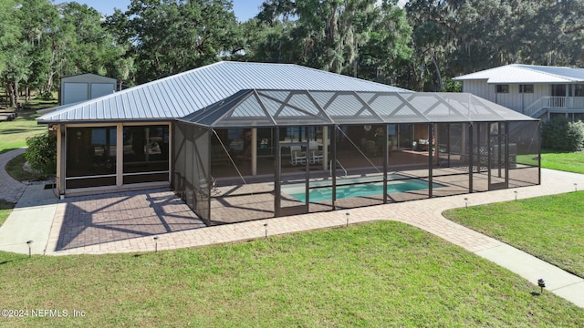 view of swimming pool featuring glass enclosure, a yard, and a patio