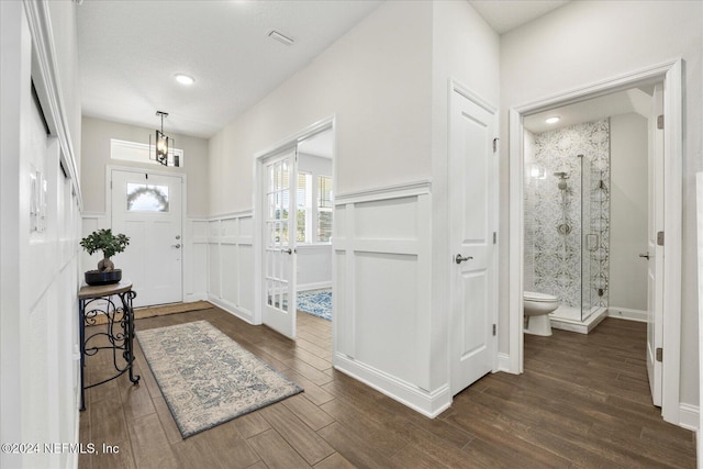 foyer featuring dark hardwood / wood-style flooring, a textured ceiling, and a chandelier