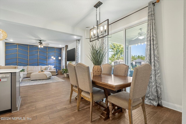 dining area featuring ceiling fan with notable chandelier and hardwood / wood-style flooring