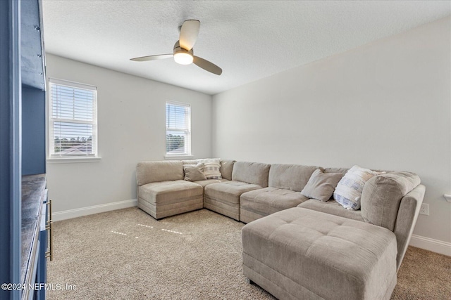 living room with a textured ceiling, carpet floors, and ceiling fan