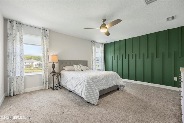 bedroom featuring ceiling fan, carpet, and a textured ceiling