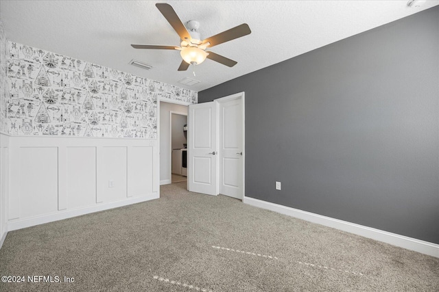 unfurnished bedroom featuring ceiling fan, carpet floors, and a textured ceiling