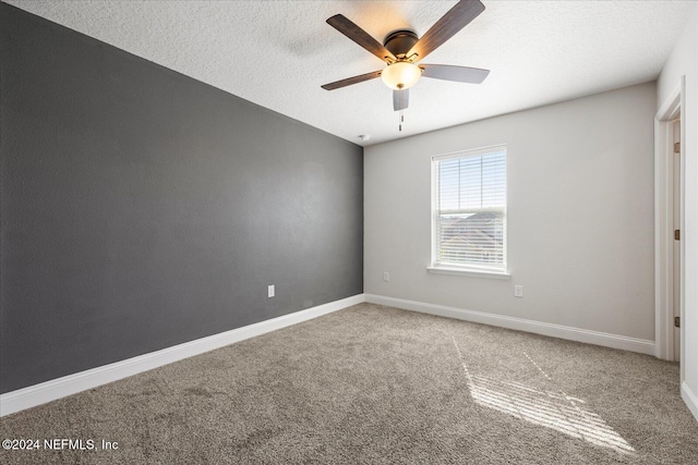 empty room featuring ceiling fan, carpet floors, and a textured ceiling