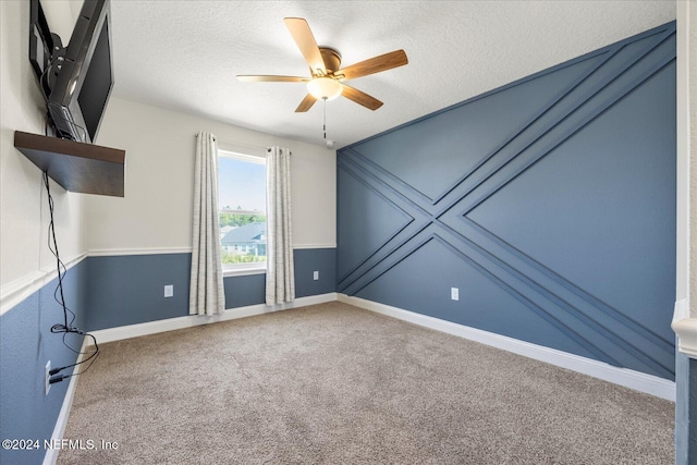 unfurnished room with carpet flooring, ceiling fan, and a textured ceiling