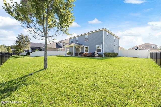 rear view of property with a yard