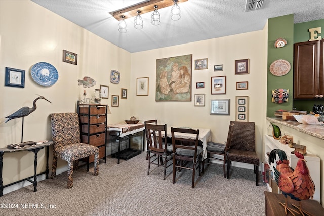 carpeted dining room featuring a textured ceiling