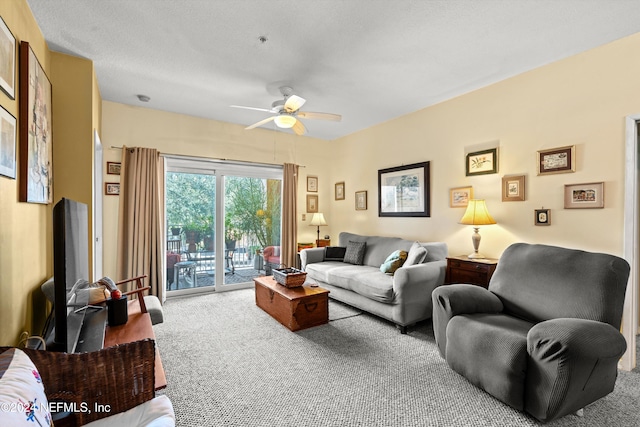 living room featuring carpet flooring, a textured ceiling, and ceiling fan