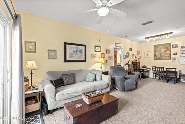 living room with ceiling fan, light colored carpet, and track lighting