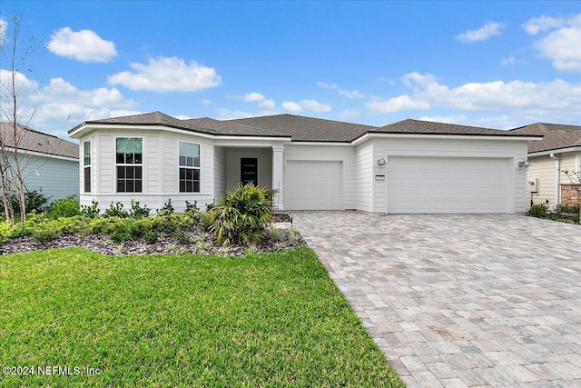 view of front of house featuring a garage and a front lawn