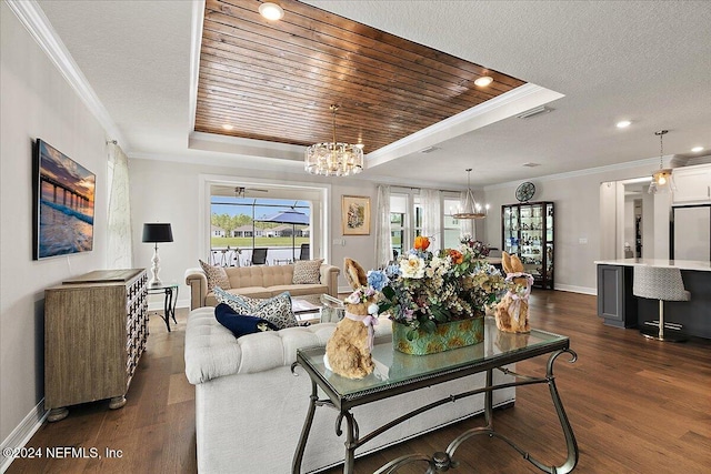 living room featuring a tray ceiling, crown molding, dark hardwood / wood-style flooring, and a notable chandelier