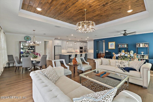 living room featuring ornamental molding, dark wood-type flooring, a tray ceiling, and wooden ceiling