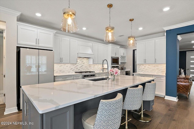 kitchen with a large island with sink, crown molding, white cabinets, and stainless steel appliances