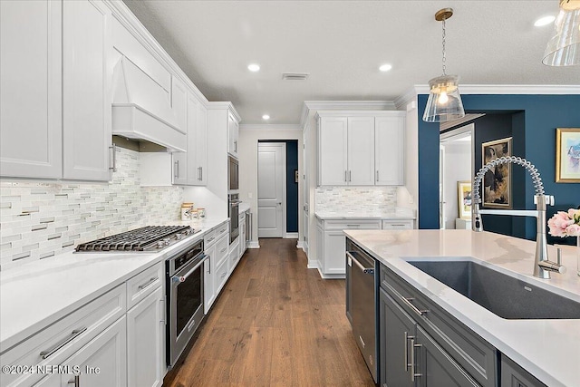 kitchen with dark wood-type flooring, decorative light fixtures, white cabinetry, and crown molding