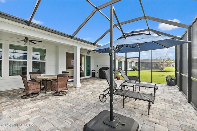 view of patio with glass enclosure and ceiling fan