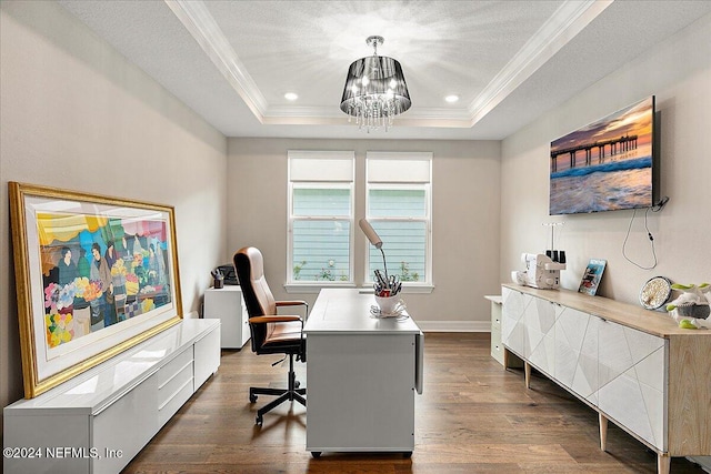 office space featuring a raised ceiling, dark hardwood / wood-style flooring, a chandelier, and ornamental molding